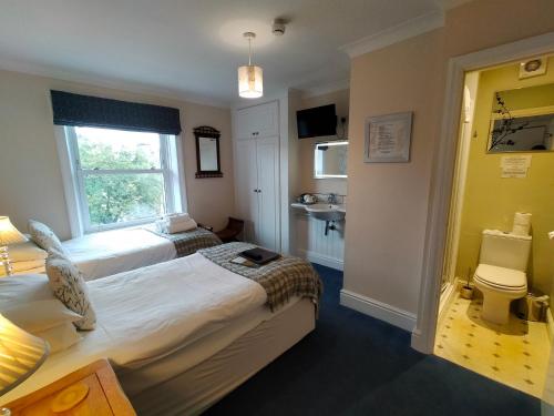 a hotel room with two beds and a window at Arden House in Harrogate