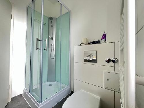 ein Bad mit einer Glasdusche und einem WC in der Unterkunft Studio Apartments nahe Stadt in Neumünster