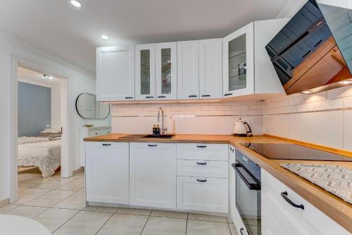 a kitchen with white cabinets and a sink at Ramada Costa Adeje Apartment in Adeje