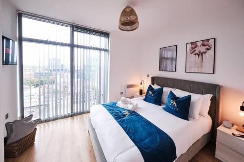 a bedroom with a large bed and a large window at Pluxa Nordic Sky - Spacious Manchester Gem 2Bed 2bath, & free parking in Manchester