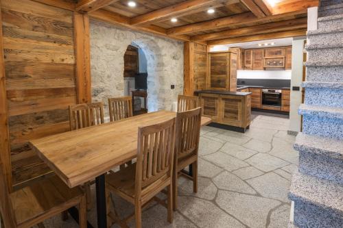a dining room with a wooden table and chairs at Maroc Mountain Chalet in Madonna di Campiglio