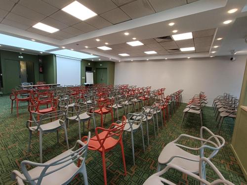 an empty room with red and white chairs at Ibis Styles Lisieux Normandie in Lisieux