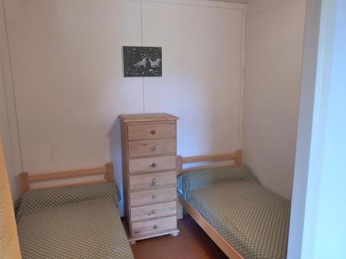 une chambre avec deux lits jumeaux et une commode dans l'établissement CBU Le Sauze, à Enchastrayes