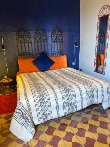 a bedroom with a bed with orange and blue at Riad N10 in Marrakech