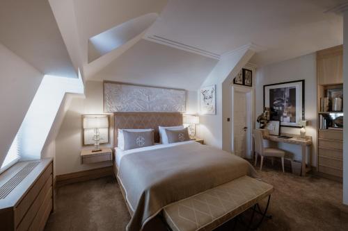 a bedroom with a large bed and a desk at Schlosshotel Berlin by Patrick Hellmann in Berlin
