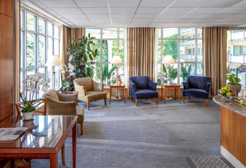 a lobby with chairs and tables and windows at Park Lane Suites & Inn in Portland