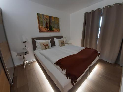 um quarto com uma cama com lençóis brancos e uma janela em Hochalmbahnen Chalets Rauris 1-05 WE1 Maislaufeldweg 1h EG em Rauris