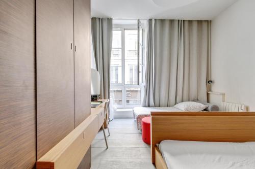 une chambre d'hôtel avec deux lits et une fenêtre dans l'établissement Élégance confort à l’Odéon by Weekome, à Paris