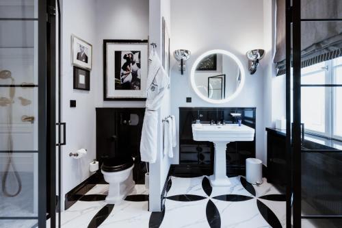 a bathroom with a sink and a toilet and a mirror at Schlosshotel Berlin in Berlin