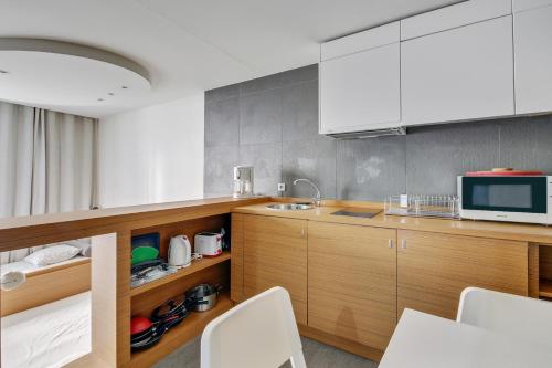 une cuisine avec un évier et un micro-ondes dans l'établissement Élégance confort à l’Odéon by Weekome, à Paris