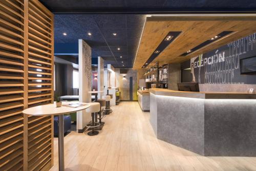 a restaurant with a bar with tables and chairs at Ibis Budget Bilbao Barakaldo in Barakaldo