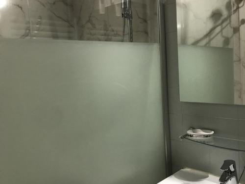 une salle de bain avec un lavabo, une douche et un miroir dans l'établissement Studio 4 pers avec balcon, proche centre et pistes - L'Alpe d'Huez - FR-1-405-20, à L'Alpe-d'Huez