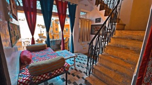 a room with a staircase with a chair and a couch at Rumis Guest House in Jaisalmer