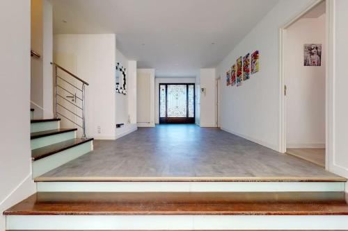 a hallway with white walls and stairs in a house at 08.Studio#Creteil#Loft#Exclusif in Créteil