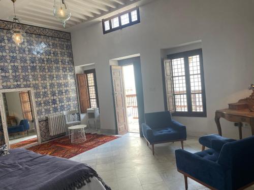 a bedroom with a bed and two chairs and a table at Maison typique de la médina in Tunis
