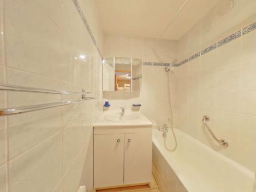 La salle de bains est pourvue d'un lavabo, d'une baignoire et d'une douche. dans l'établissement Appartement Les Saisies, 2 pièces, 8 personnes - FR-1-594-41, à Hauteluce