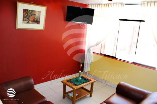 a living room with a red wall and a lamp on a table at ANDENES DEL TITICACA in Puno