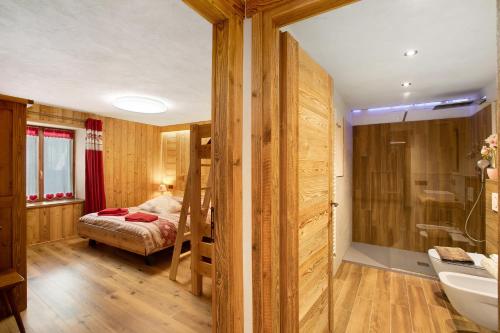 a bathroom with a bed and a sink in a room at Jorasses La Maison de Courma in Courmayeur