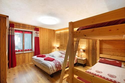 a bedroom with two bunk beds and a window at Jorasses La Maison de Courma in Courmayeur