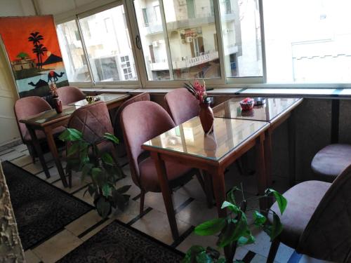 um quarto com uma mesa, cadeiras e janelas em Hotel Panorama no Cairo