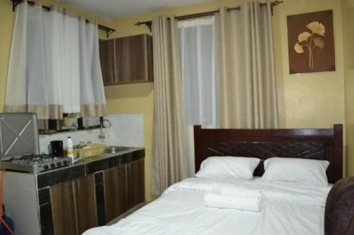um quarto com uma cama e uma cozinha com um fogão em ROSEVIEW em Kiambu