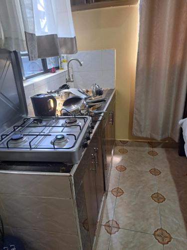 uma cozinha com uma placa de fogão e forno. em ROSEVIEW em Kiambu
