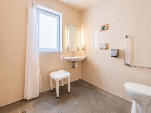 a bathroom with a sink and a toilet and a window at B&B HOTEL Strasbourg Sud Ostwald in Ostwald