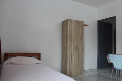 1 dormitorio con 1 cama y armario de madera en HIME LODGE en Papeete