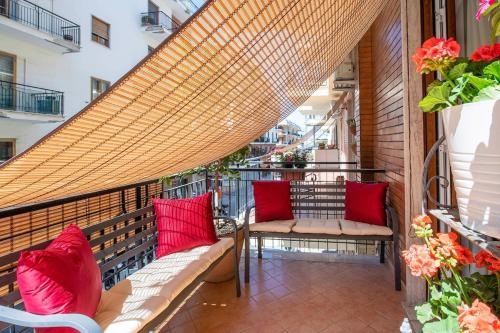 a balcony with two benches and red pillows at Gemma di Zagara Apartment in Sorrento