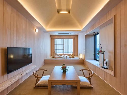 奈良市にあるホテルニューわかさのテーブル、椅子、テレビが備わる客室です。