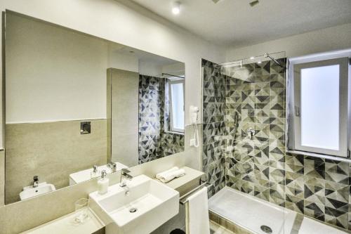 ein Badezimmer mit einem Waschbecken, einem Spiegel und einer Badewanne in der Unterkunft Casa Arthemisia in Sorrent
