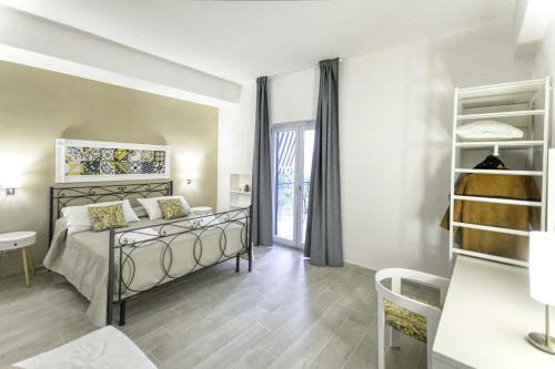 ein Schlafzimmer mit einem Bett in einem Zimmer mit einem Fenster in der Unterkunft Casa Arthemisia in Sorrent