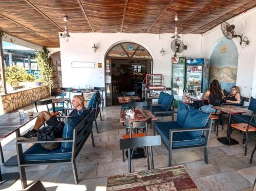 um grupo de pessoas sentadas em cadeiras em um restaurante em Calypso Hotel em Lipsoi