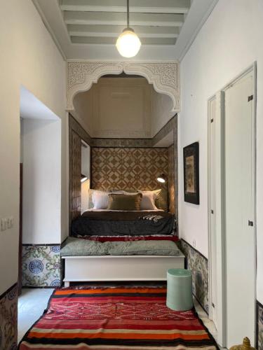 a bedroom with a bed with a large headboard at Maison typique de la médina in Tunis