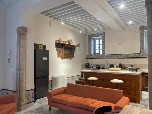uma sala de estar com um sofá e uma cozinha em Maison typique de la médina em Tunes