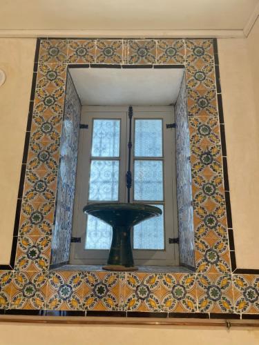 a window in a room with a tile wall at Maison typique de la médina in Tunis