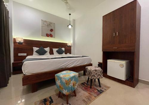 1 dormitorio con 1 cama y 2 sillas en Baga Keys by RJ14, en Old Goa