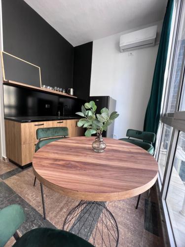 a dining room table with a vase of flowers on it at Cactus Apartments in Durrës