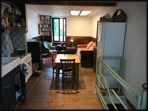 Il dispose d'une cuisine et d'un salon avec un réfrigérateur et une table. dans l'établissement Maisonnette art déco, à Choriol