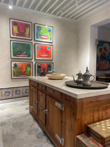 a room with a counter with paintings on the wall at Maison typique de la médina in Tunis