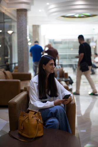 a woman sitting in a chair with a purse at El Sheikh Suites Hotel in Beirut