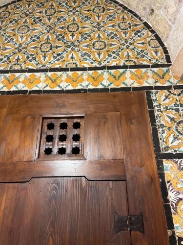 a wooden door with a tiled wall above it at Maison typique de la médina in Tunis