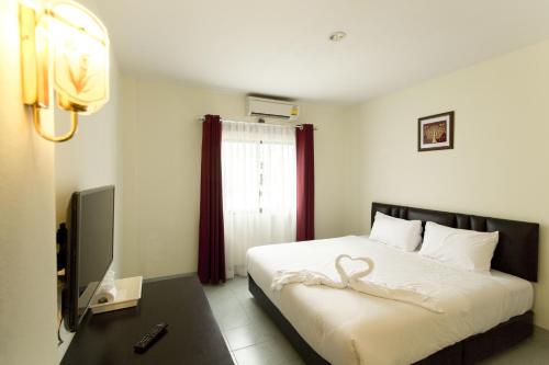 Un dormitorio con una cama con un cisne. en Paripas Express Patong, en Patong Beach