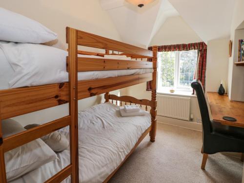 a bedroom with two bunk beds and a desk at 1 Tan Yr Ywen in Conwy