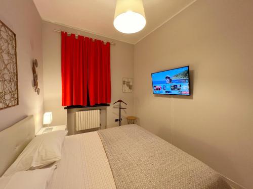 een slaapkamer met een bed en een flatscreen-tv bij La Borasca - Apartments in Casalpusterlengo