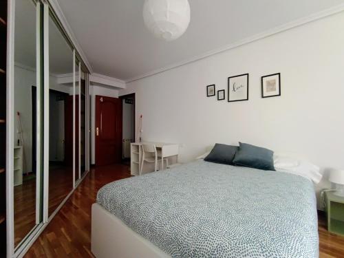 a white bedroom with a bed and a mirror at El Portazgo Restaurante Hostal La Cisterniga in La Cistérniga