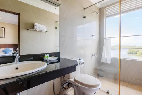 ein Bad mit einem Waschbecken, einem WC und einer Dusche in der Unterkunft The Waterfront in Negombo