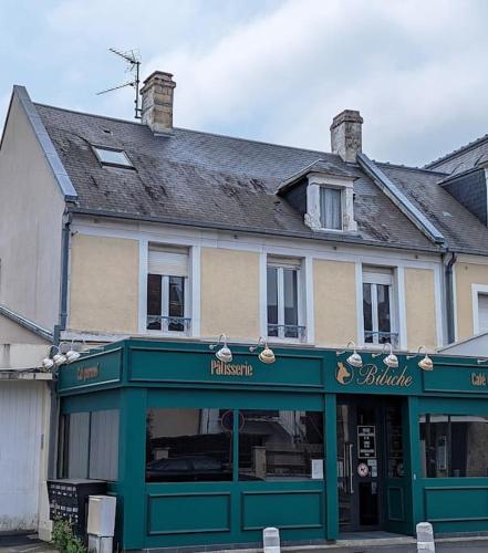 un bâtiment avec une vitrine verte en face de celui-ci dans l'établissement Studio calme et cosy, à Caen