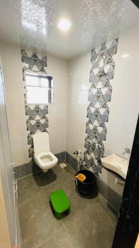 a bathroom with a toilet and a sink at Devka House HomeStay in Daman
