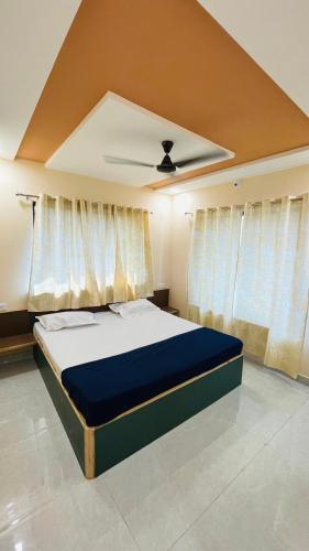 a bedroom with a bed in a room with curtains at Devka House HomeStay in Daman